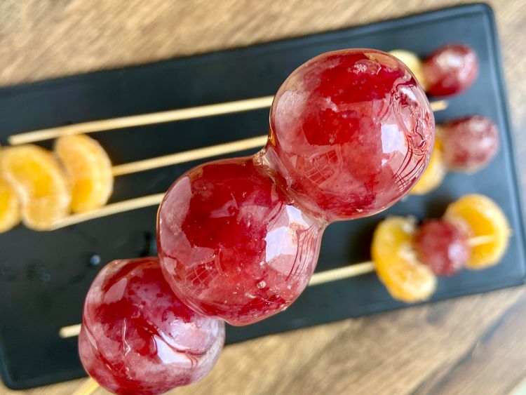 Dip the fruits in hot sugar syrup, let them cool, then serve immediately on a tray.