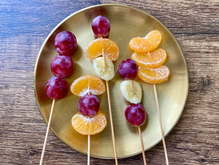 Skewer the fruits onto wooden skewers according to your preference.