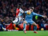 Arsenal's midfielder Bukayo Saka (L) fights for the ball 