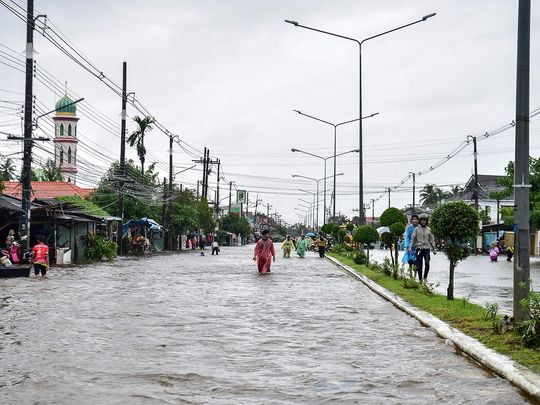 People through flood waters along a street