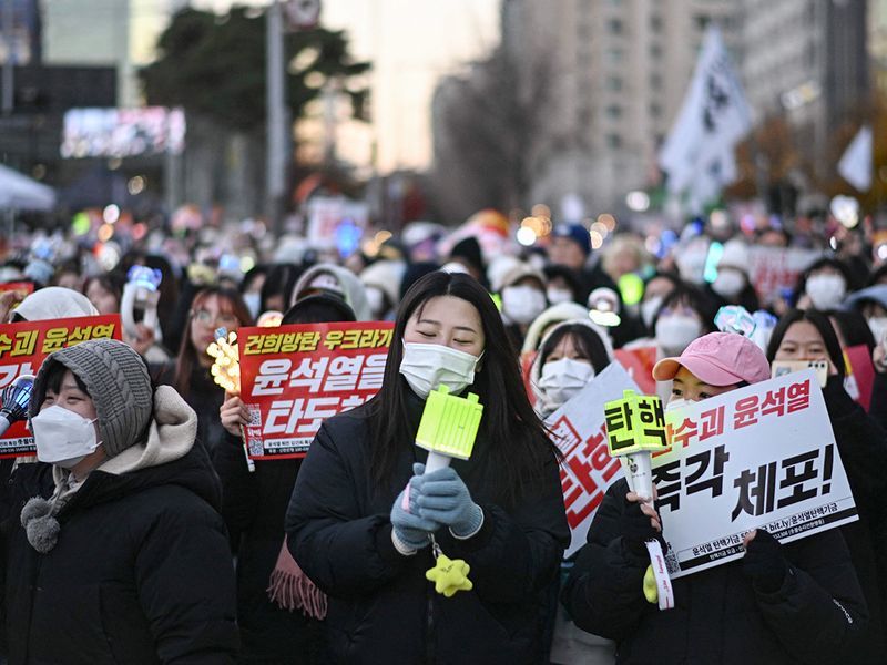 People sing along K-pop music during a protest