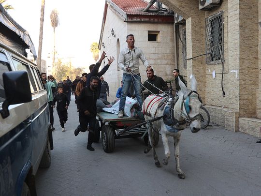 Palestinians transport wounded people into the Al Ahli Arab hospital